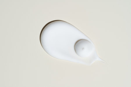High-shine cream swipe on neutral beige, showing deep hydration and a plumping finish for premium anti-aging product visuals.の写真素材