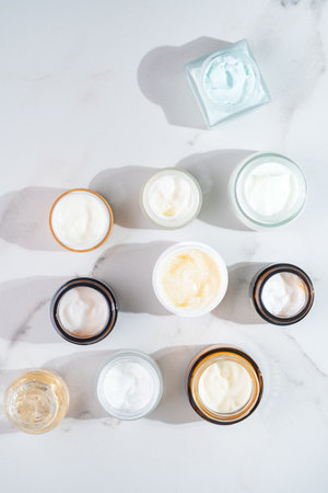 Flat Lay of Multiple Open Cream Jars on Marble. Skincare Collection, Luxury Beauty Products, Minimalist Aestheticの写真素材