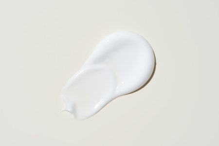 Luxurious cream dabbed and blended on neutral surface, highlighting smooth application for moisturizer campaigns.の写真素材