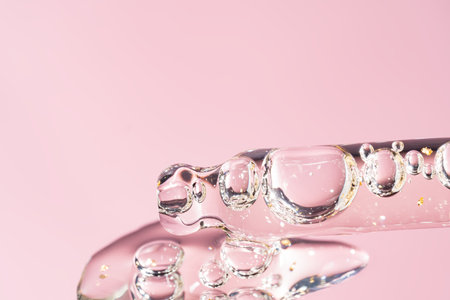 A drop of cosmetic gel or face serum oil falls from the pipette. Cosmetic product textureの写真素材