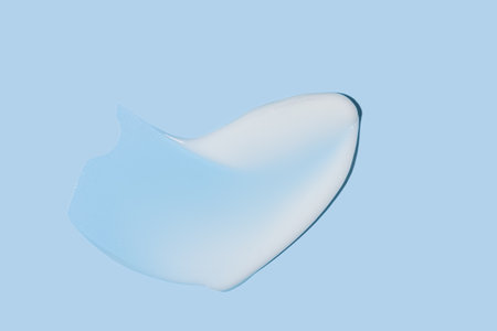 White cosmetic cream texture, skincare lotion swatch on blue background. Face creme, body moisturizer, hair conditioner smear smudge stroke. Creamy beauty product closeupの写真素材