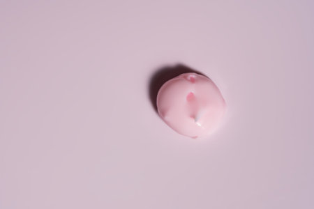 Cosmetic cream texture on pink background. Skin care product smear. Lotion, hair mask or other...