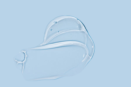 Glycerin gel texture. Transparent serum drop on blue background. Liquid gel moisturizer with bubbles...