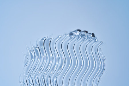 Glycerin gel texture. Transparent serum drop on blue background. Liquid gel moisturizer with bubbles macro.の写真素材