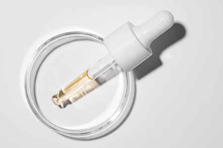 Cosmetic pipette with oil on white background close-up. Stylish concept of organic essences, beauty...