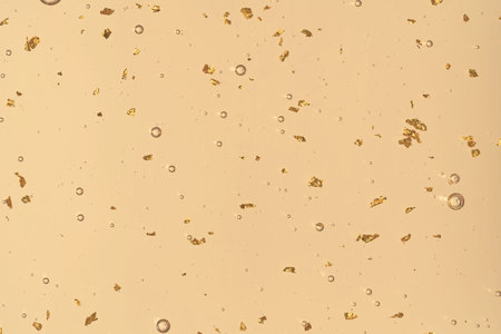 Luxury transparent serum with sparkling 24k gold particles, perfect for beauty products, wellness...