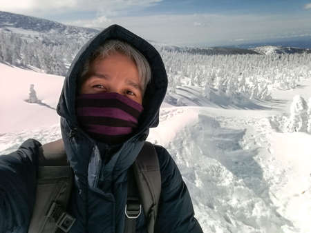 Young Man Smile Camera Taking Selfie Photo on top viewpoint mountain Zao, Yamagata. with snow monster background.の写真素材