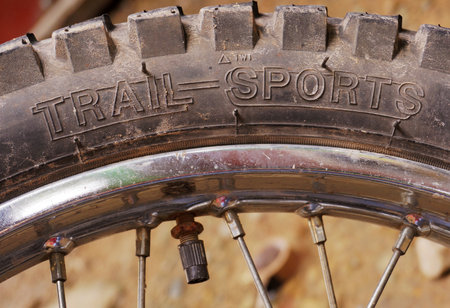 Trail sports text on dusty tire of a motorcycle after travelling on rough and winding roads. An image for outdoor activities topic. Photo taken in Benguet, Philippines on October 6, 2019.のeditorial素材