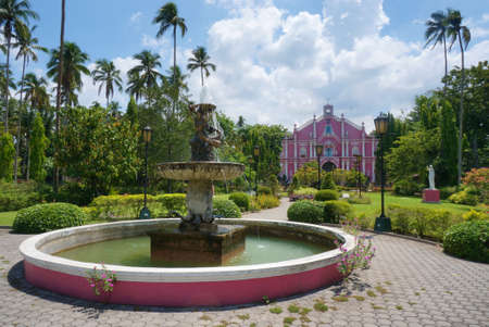 Old fountain and pink Catholic church in Quezon, Philippines, Southeast Asia. Photo taken on Mat 1, 2014.のeditorial素材