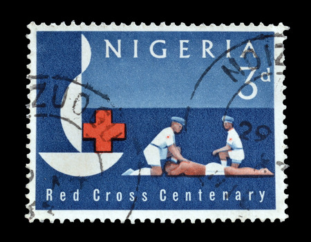 NIGERIA - CIRCA 1963 : Postage stamp printed by Nigeria, that show two men giving first aid.のeditorial素材