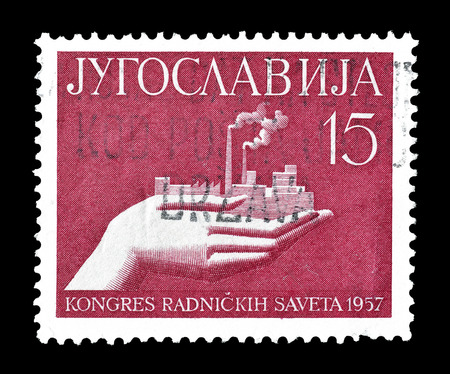 Cancelled postage stamp printed by Yugoslavia, that shows hand holding a factory, circa 1957.のeditorial素材