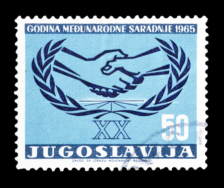 Cancelled postage stamp printed by Yugoslavia, that shows two hands shaking, Symbolizing international cooperation of the UNO, circa 1965.のeditorial素材