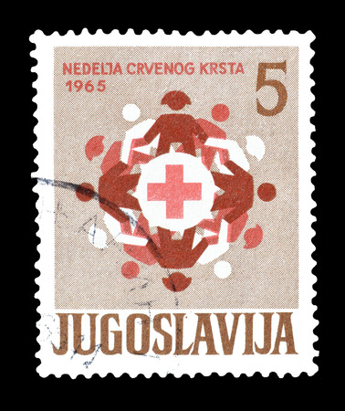 Cancelled postage stamp printed by Yugoslavia, that shows children dancing around red cross, circa 1965.のeditorial素材