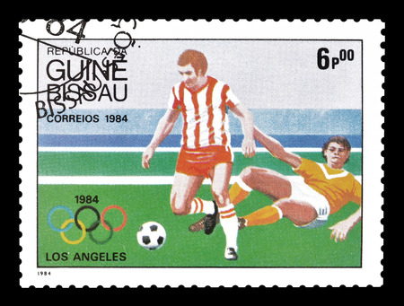 Cancelled postage stamp printed by Guinea Bissau, that shows football players, circa 1984.のeditorial素材