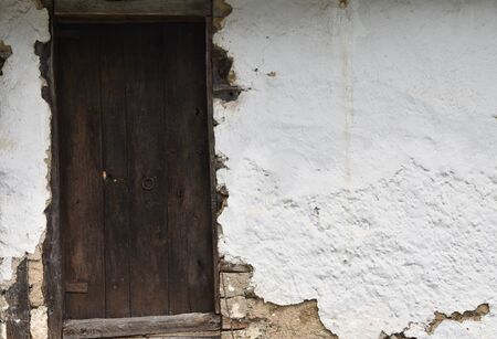 Old wooden door and white wallの写真素材