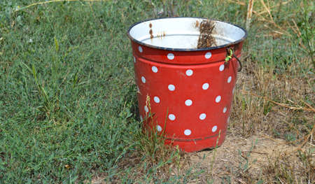 Beautiful red and white vintage bucket in rural part of the countryの写真素材