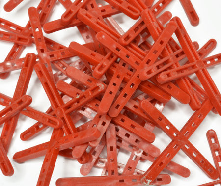 Pile of red Tile crosses used for the proper positioning of the ceramic tiles and forming of balanced spaceの写真素材