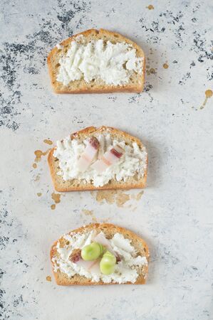Three italian bruschetta with ricotta cheese, italian pancetta and broad beans. White background.の写真素材