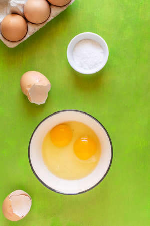 Cracked egg with Yolk egg in ceramic bowl and raw eggsの写真素材