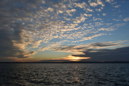 Sunset over the lake with clouds in the sky. Nature background.の写真素材