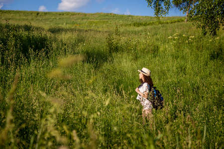 Girl with a backpack in the field.の写真素材