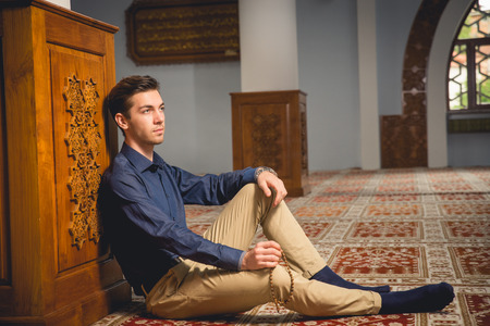 Young Muslim man praying in a mosque.の写真素材