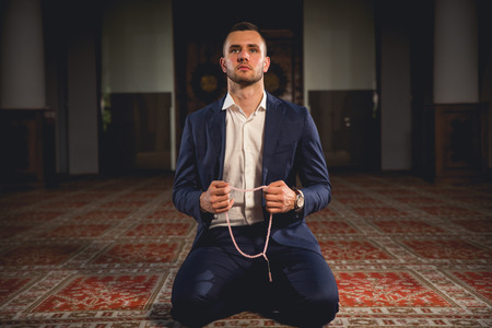 Young Muslim man praying in a mosque.の写真素材