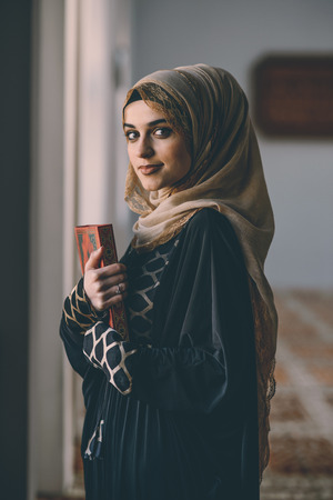 Young Muslim girl holding holy book Koranの写真素材