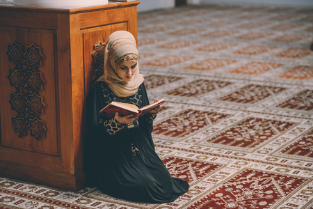 Muslim woman reading holy book Koran