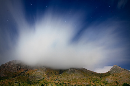 Clouds over Mount Inici - Castellammare del Golfo. The panorama is lit by the moonlightの写真素材