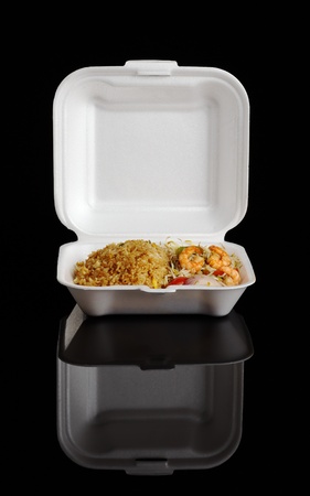Chinese take-away food: Fried rice with king prawns and vegetables in a  box photographed on black の写真素材