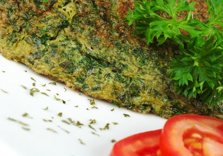 Omelette with herbs on white plate with parsley and tomato slices (Selective Focus)の写真素材