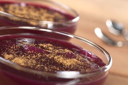 Popular Peruvian dessert called Mazamorra morada, which is made from purple corn, fruits and spices and is garnished with cinnamon powder (Selective Focus, Focus on the middle of the first dessert)の写真素材