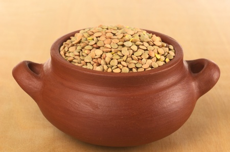 Raw dried lentils in rustic bowl on wood (Selective Focus, Focus on the lentils in the front of the bowl)の写真素材