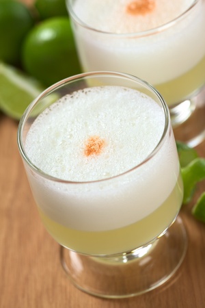 Peruvian cocktail called Pisco Sour made of Pisco (Peruvian grape schnaps), lime juice, syrup, egg white, and some angostura (bitter fluid) drops on top (Selective Focus, Focus on the middle of the angostura)の写真素材