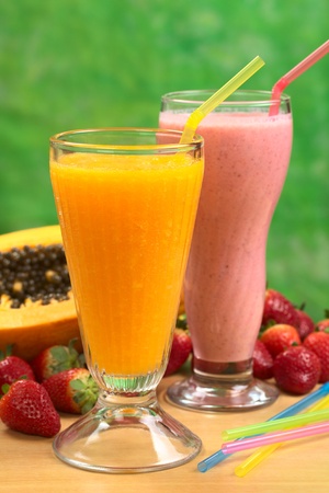 Papaya juice and strawberry milkshake with straws (Selective Focus, Focus on the straw in the papaya juice)の写真素材