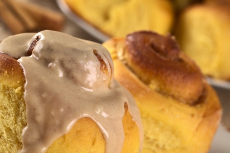 Pumpkin cinnamon roll with cinnamon icing (Selective Focus, Focus on the front upper edge of the roll and the icing)の写真素材