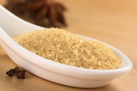 Brown granulated cane sugar with cloves and star anise (Selective Focus, Focus one third into the spoon) の写真素材