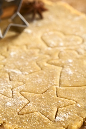 Christmas shapes cut out on cookie dough (Selective Focus, Focus on the right lower part of the star shaped cookie)の写真素材