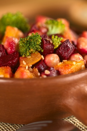 Pumpkin, beetroot, broccoli and chickpea salad garnished with sesame seeds (Selective Focus, Focus on the bigger broccoli floret in the front and the vegetables around it) の写真素材