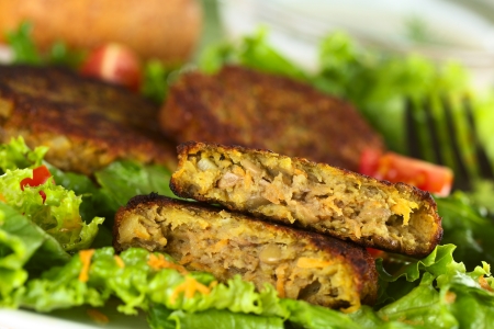 Vegetarian lentil burger made of brown lentils and grated carrots served on lettuce (Selective Focus, Focus on the upper half burger)の写真素材