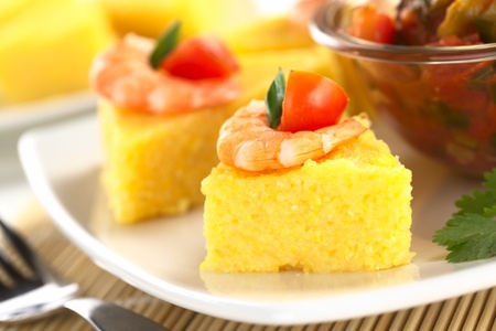 Polenta slices with shrimp and cherry tomato accompanied by hogao, a Colombian sauce made of tomato, onion and cilantro (Selective Focus, Focus on the front of the shrimp) の写真素材