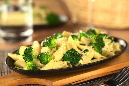 Baked broccoli and pasta with melted cheese and ground pepper on top (Selective Focus, Focus one third into the image) の写真素材