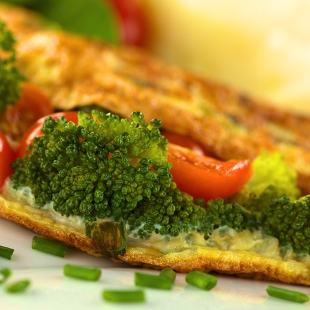 Broccoli and tomato omelette with mashed potato in the back (Selective Focus, Focus on the broccoli floret on the left)の写真素材