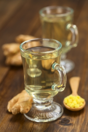 Freshly prepared hot ginger tea made of fresh ginger root served in glass (Selective Focus, Focus on the front of the rim and the handle of the glass)の写真素材
