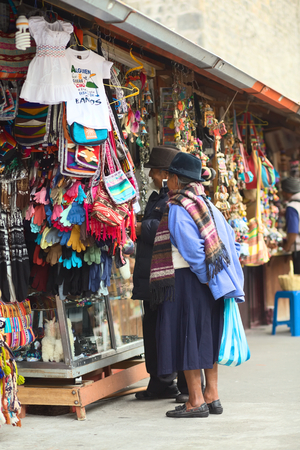 BANOS, ECUADOR - FEBRUARY 22, 2014: Unidentified elderly people standing at a handicraft stand in the Pasaje Artesanal (Artisan Passage) on February 22, 2014 in Banos, Ecuador. のeditorial素材