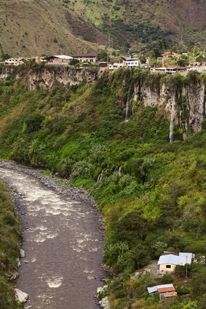 The Pastaza River and the small town of Banos in Ecuador on the cliffs with some waterfalls dropping down の写真素材