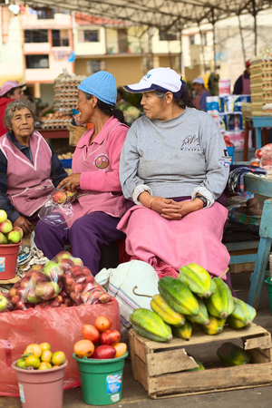 BANOS, ECUADOR - FEBRUARY 26, 2014  Unidentified female vendors on the market on Plaza 5 de Junio on February 26, 2014 in Banos, Ecuador  On the market, which is held every Wednesday, Friday and Sunday, mainly fruits and vegetables are being offered, withのeditorial素材