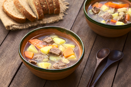 Two bowls of traditional Hungarian soup called Gulyasleves made of beef, potato, carrot, onion, csipetke  and seasoned with salt and paprika の写真素材