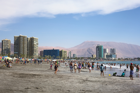 IQUIQUE, CHILE - JANUARY 23, 2015: Unidentified people enjoying the water and playing in the sand on the crowded Cavancha beach on January 23, 2015 in Iquique, Chile. Iquique is a popular beach town and free port city in Northern Chile.のeditorial素材